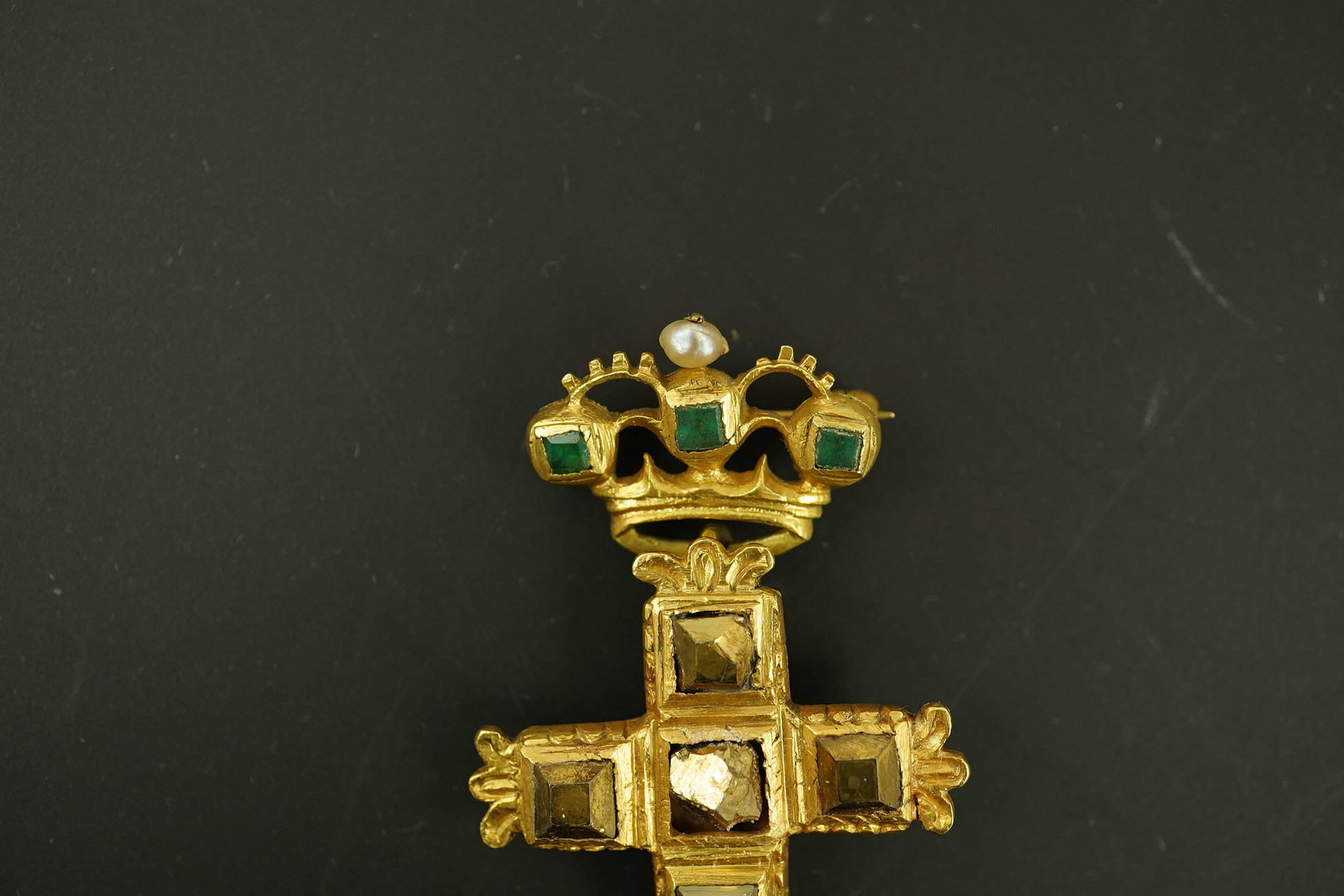 An antique continental engraved gold and seven stone pyrites? set cross pendant, with a gold, emerald and seed pearl set suspension brooch attachment